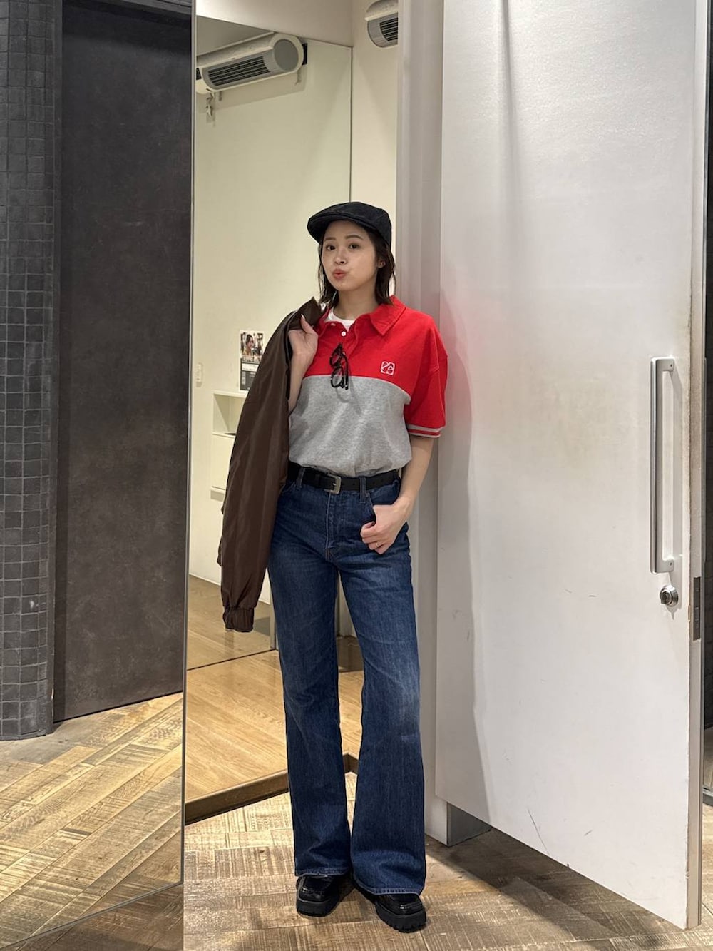 ブルー系のデニムパンツ、ブラウン系のブルゾン、ホワイト系のTシャツ/カットソーを着用したレディースの春コーディネートの2枚目の写真