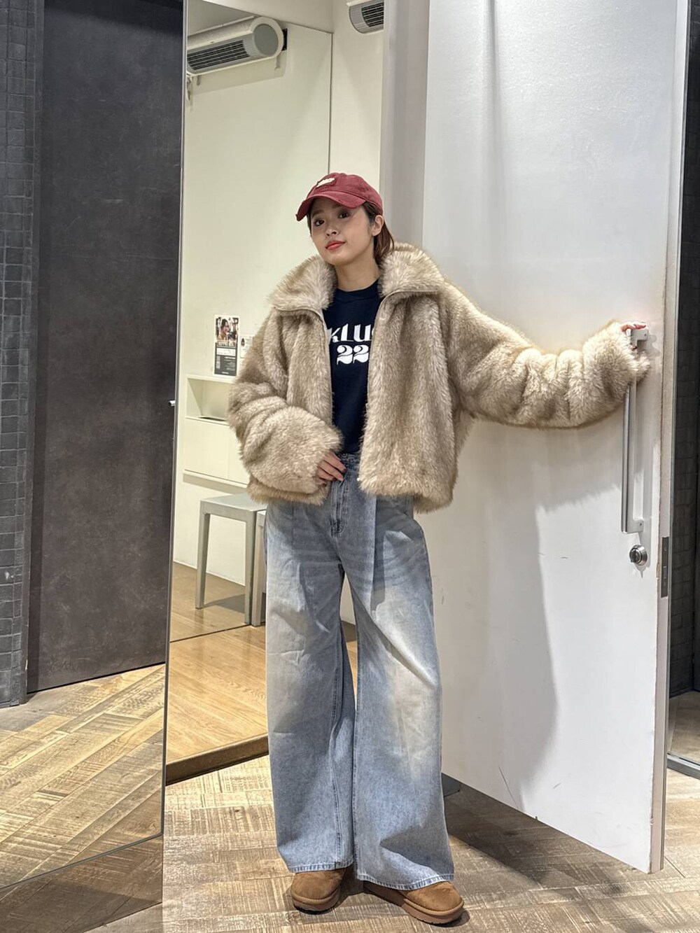 ベージュ系のブルゾン、ブルー系のデニムパンツ、ブルー系のニット/セーターを着用したレディースの冬コーディネートの4枚目の写真