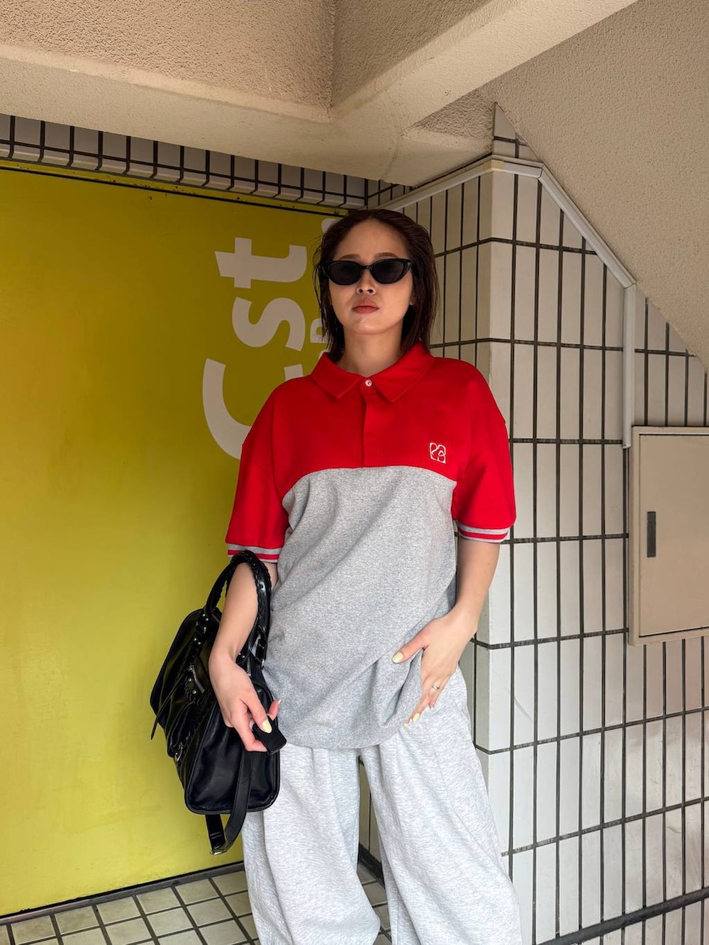 ブラック系のブーツ、ブラック系のボストンバッグ、グレー系のスウェットパンツを着用したレディースの春コーディネートの2枚目の写真