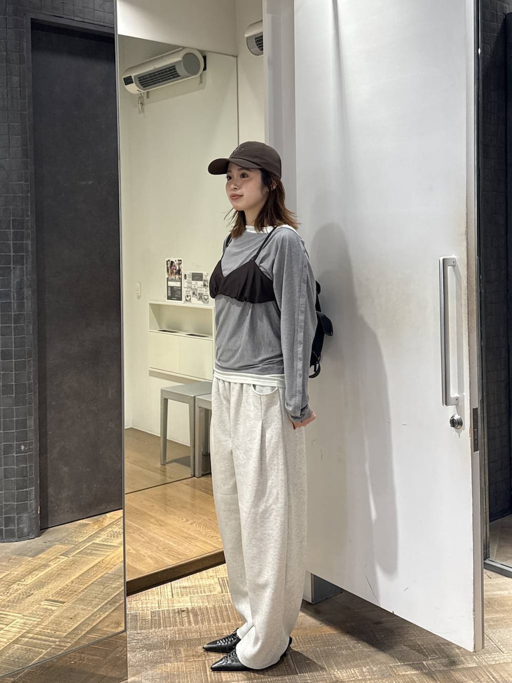 ブラック系のバックパック/リュック、ブラック系のパンプス、グレー系のTシャツ/カットソーを着用したレディースの秋コーディネートの2枚目の写真