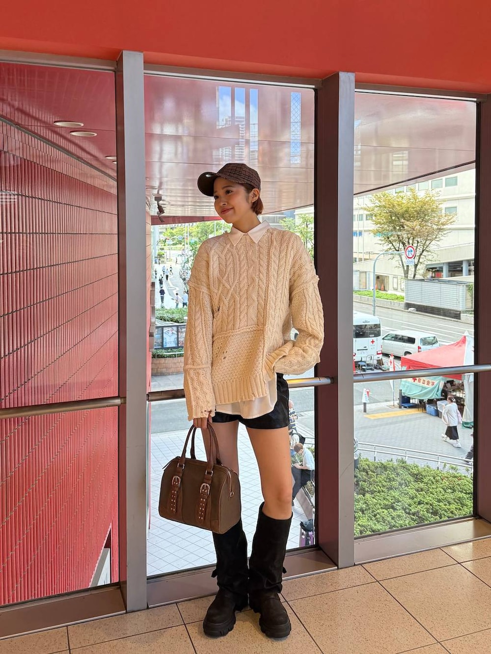 グリーン系のボストンバッグ、ブラック系のブーツ、ホワイト系のシャツ/ブラウスを着用したレディースの秋コーディネートの2枚目の写真