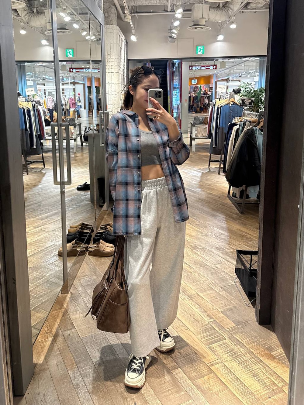 ブルー系のシャツ/ブラウス、グレー系のタンクトップ、ブラック系のスニーカーを着用したレディースの春コーディネートの2枚目の写真