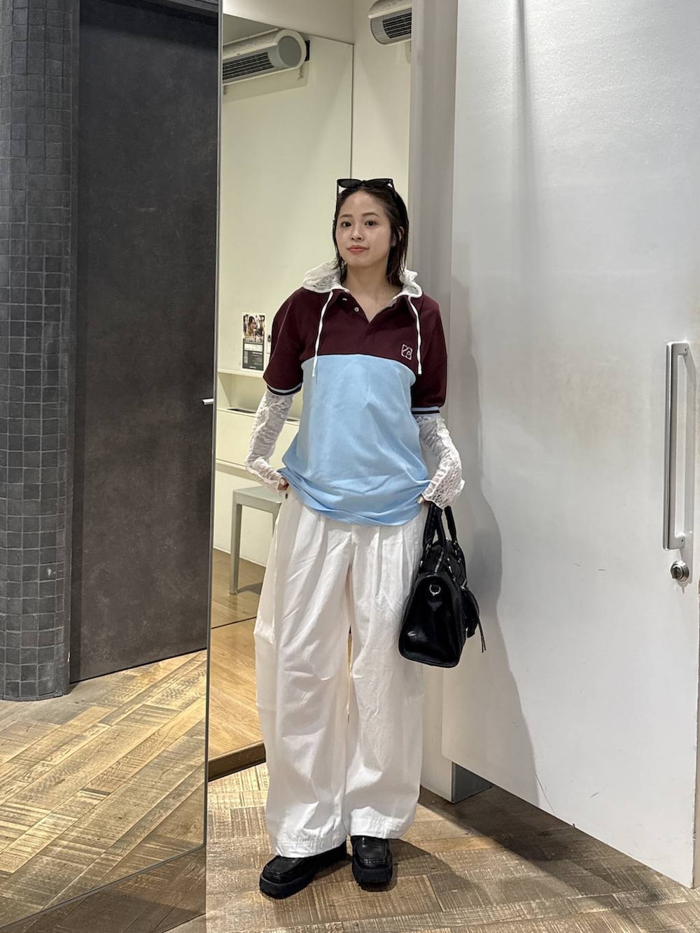 ブラック系のボストンバッグ、ホワイト系のその他パンツ、ホワイト系のパーカーを着用したレディースの春コーディネートの3枚目の写真