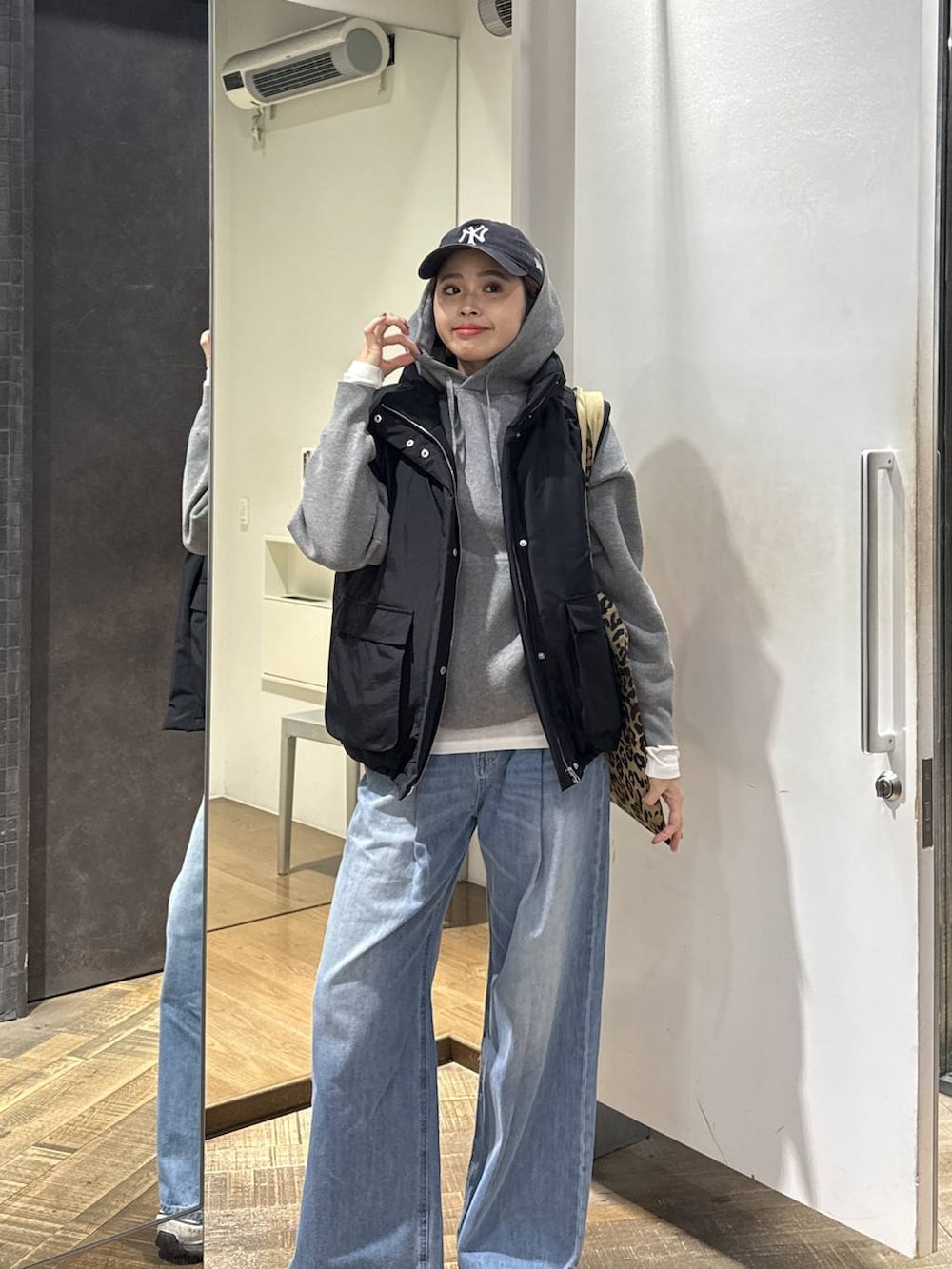 ブルー系のデニムパンツ、ベージュ系のトートバッグ、ホワイト系のスニーカーを着用したレディースの冬コーディネートの3枚目の写真