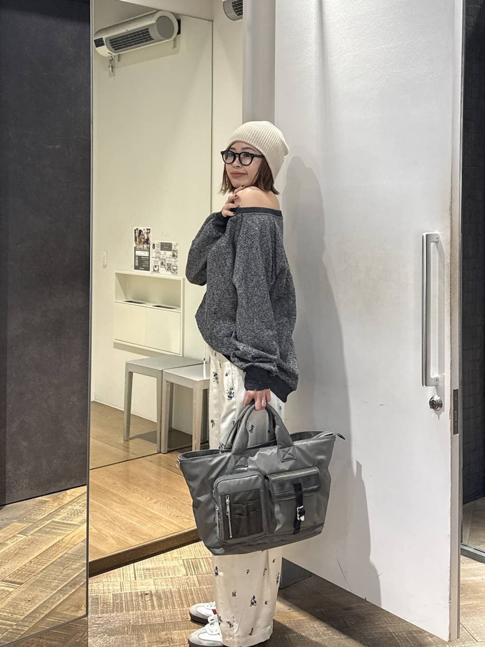 ブラック系のスウェット、グリーン系のトートバッグ、ベージュ系のその他パンツを着用したレディースの春コーディネートの2枚目の写真