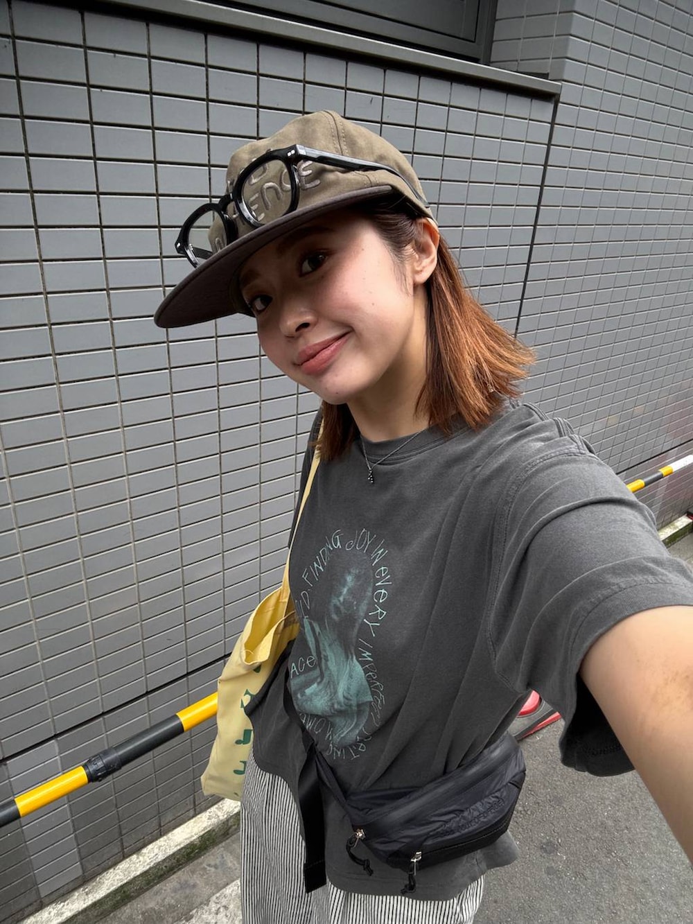 グレー系のTシャツ/カットソー、ホワイト系のデニムパンツ、ブラック系のボディバッグ/ウエストポーチを着用したレディースの夏コーディネートの4枚目の写真