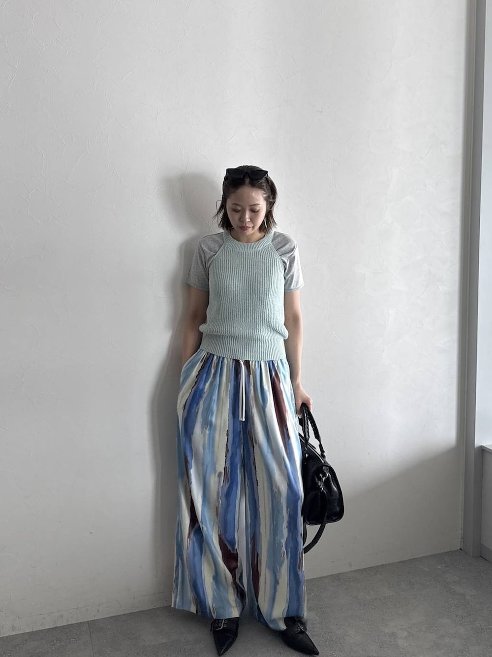 ブラック系のボストンバッグ、ブラック系のパンプス、グレー系のTシャツ/カットソーを着用したレディースの春コーディネートの3枚目の写真