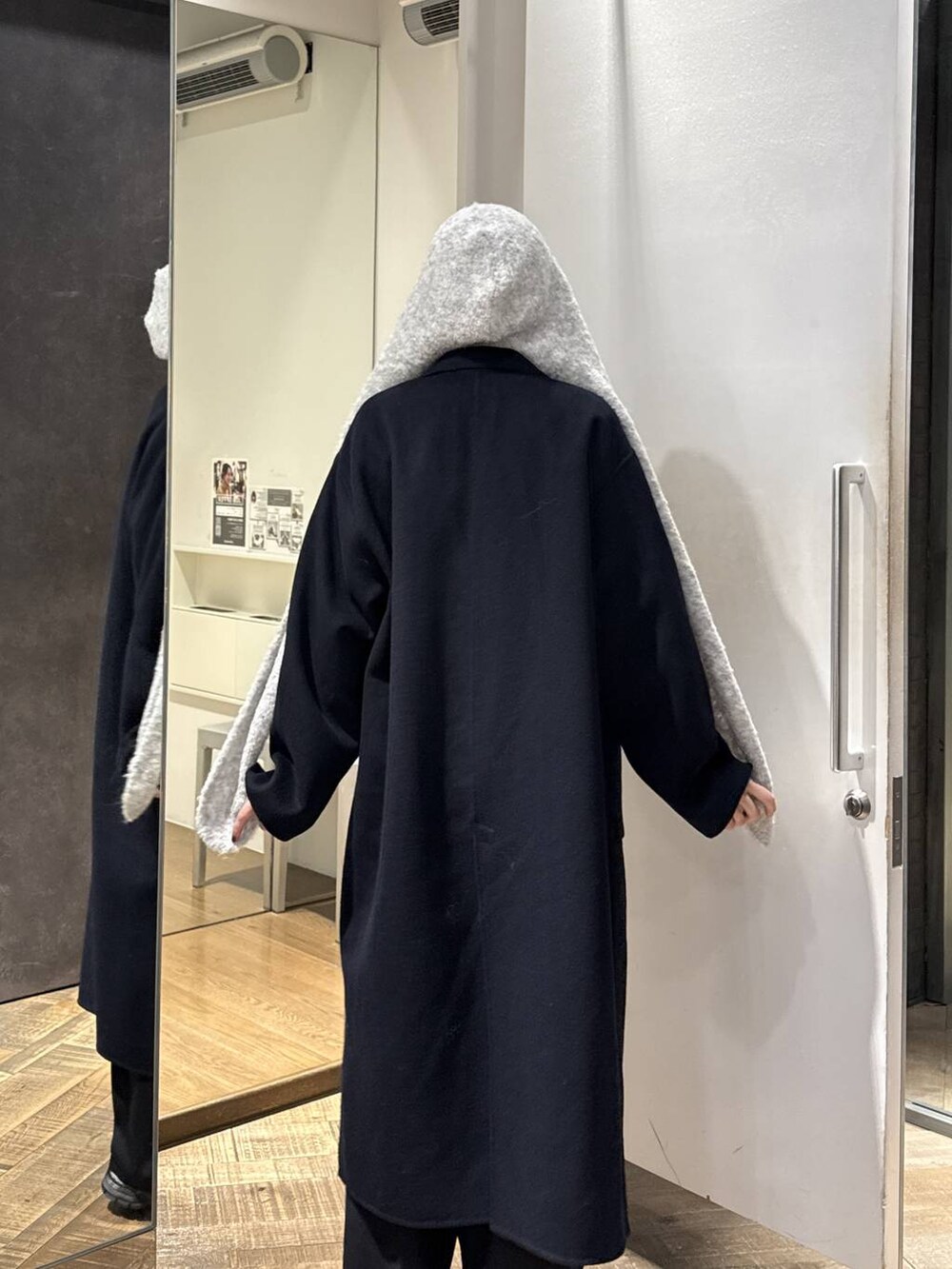 ブルー系のチェスターコート、ホワイト系のスニーカー、グレー系のカーディガン/ボレロを着用したレディースの秋コーディネートの3枚目の写真