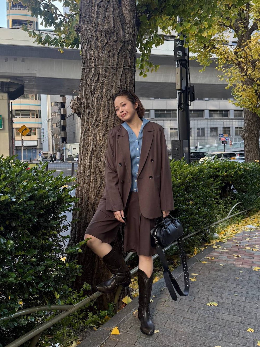 ブラウン系のテーラードジャケット、ブラック系のボストンバッグ、ブラック系のブーツを着用したレディースの冬コーディネートの3枚目の写真