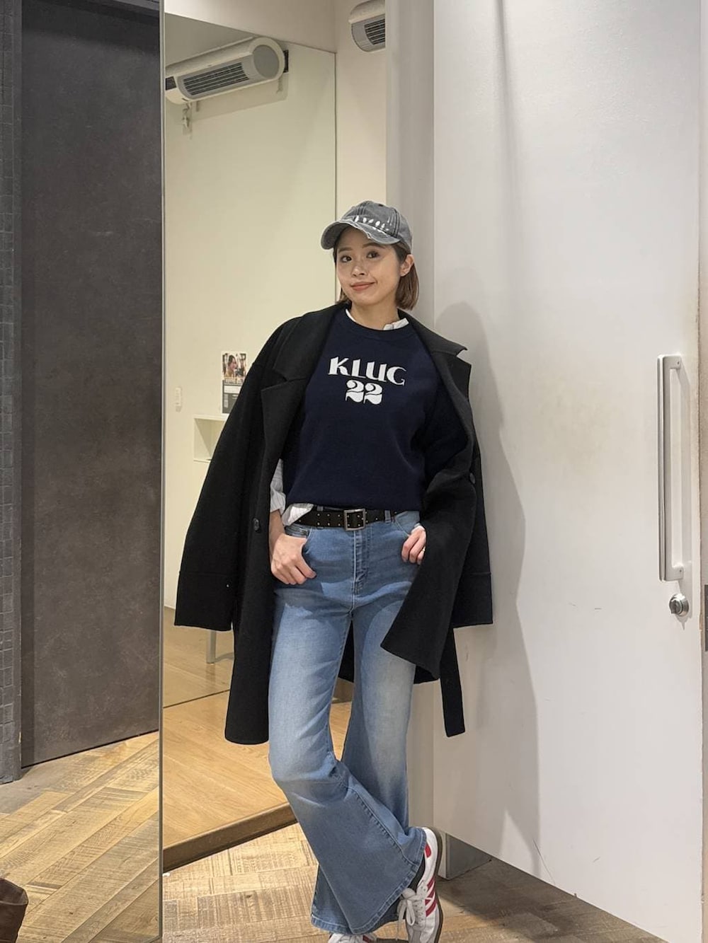 ブラック系のピーコート、ブルー系のデニムパンツ、ブルー系のニット/セーターを着用したレディースの冬コーディネートの2枚目の写真