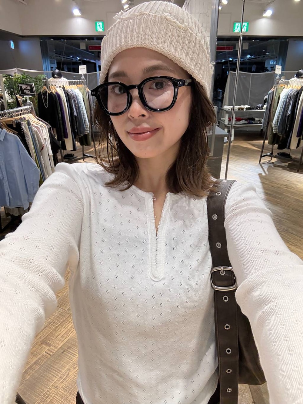 ブラウン系のショルダーバッグ、ホワイト系のTシャツ/カットソー、ブラウン系のデニムパンツを着用したレディースの秋コーディネートの3枚目の写真