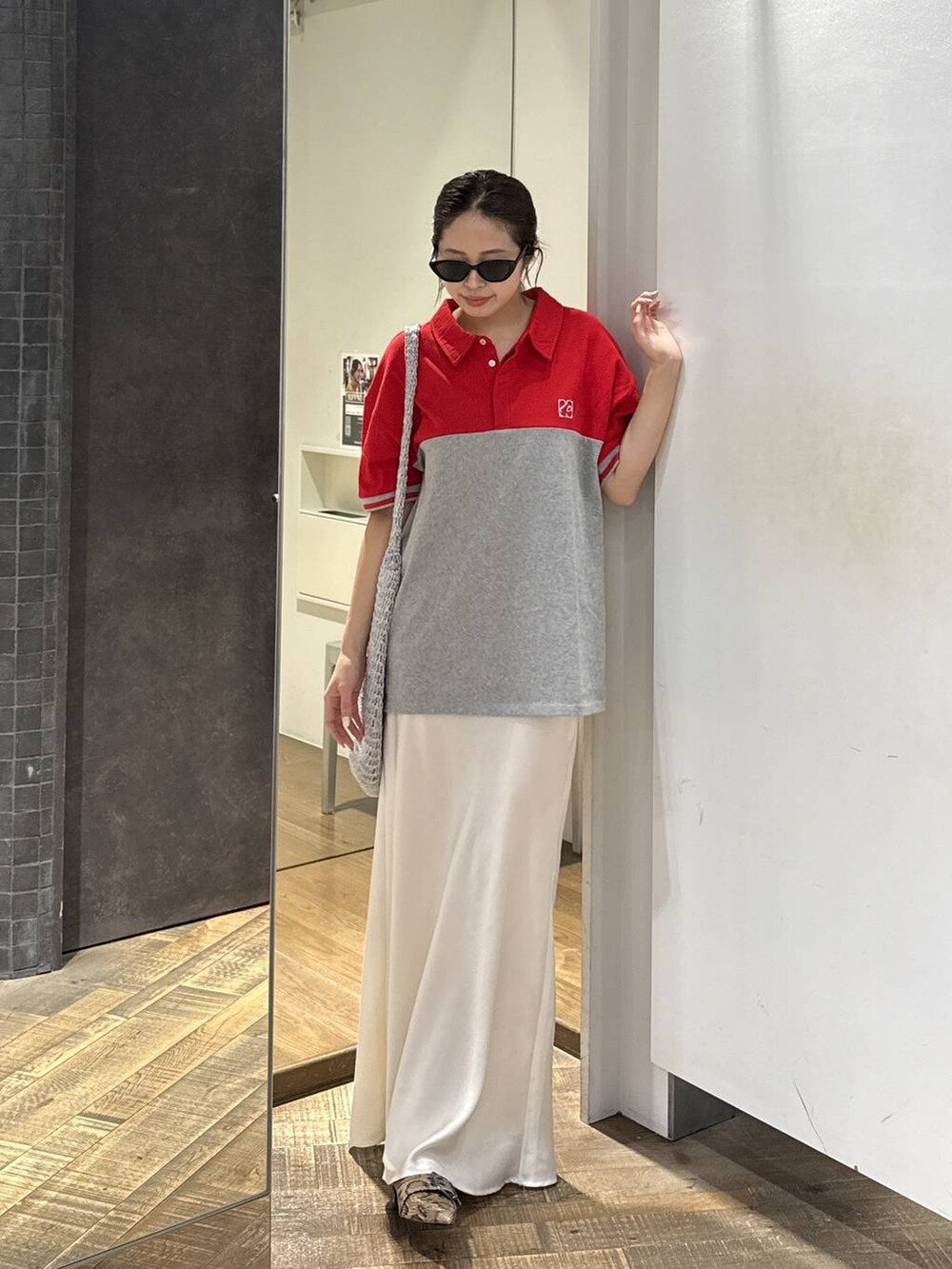 シルバー系のショルダーバッグ、ベージュ系のパンプス、ホワイト系のスカートを着用したレディースの春コーディネートの2枚目の写真