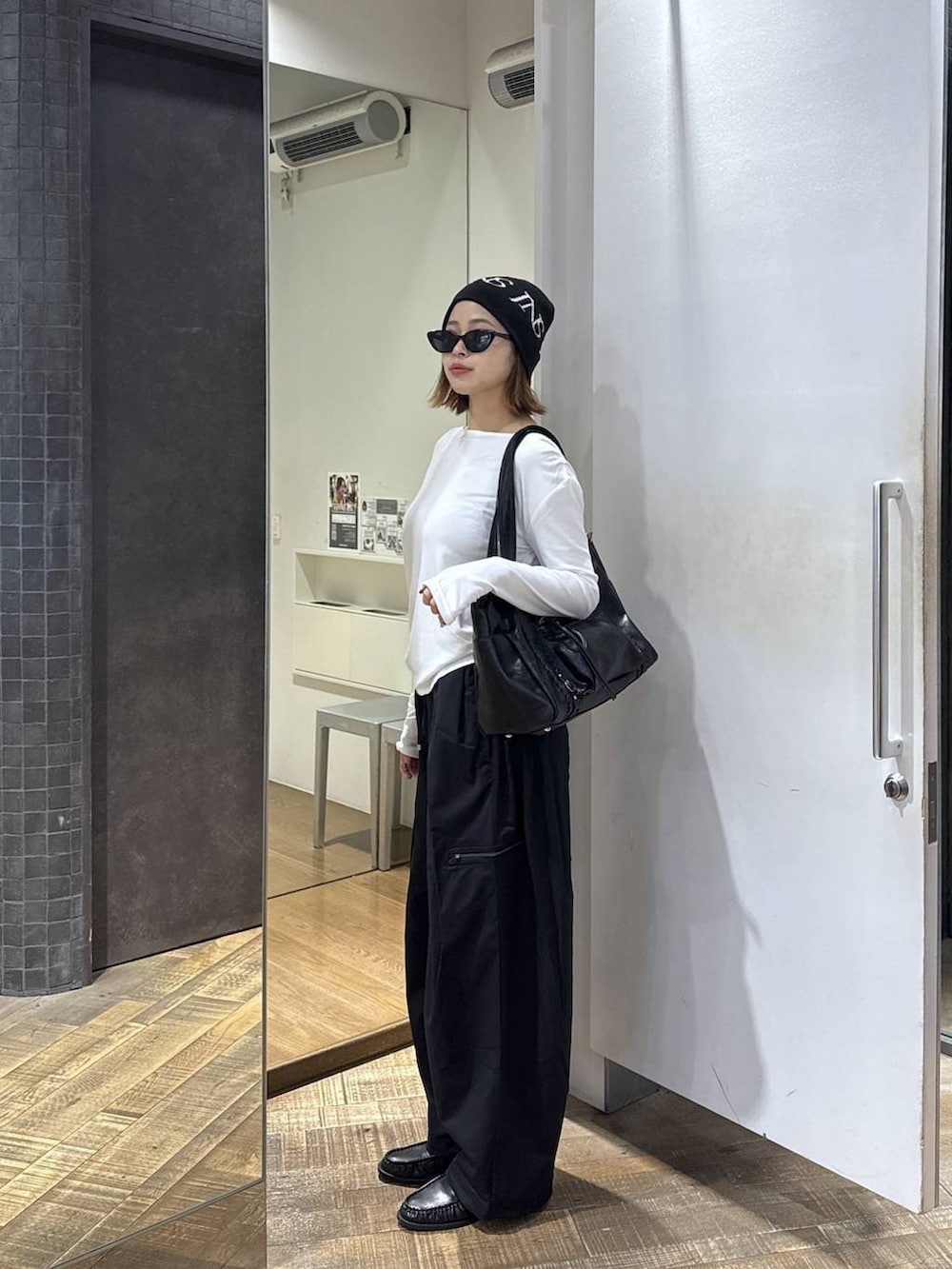 ホワイト系のTシャツ/カットソー、ブラック系のカーゴパンツ、ブラック系のトートバッグを着用したレディースの冬コーディネートの2枚目の写真