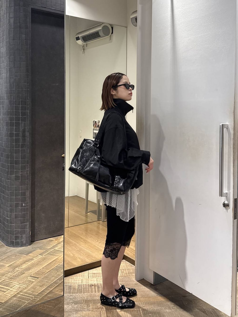 ホワイト系のTシャツ/カットソー、ブラック系のトートバッグ、ブラック系のドレスシューズを着用したレディースの春コーディネートの2枚目の写真