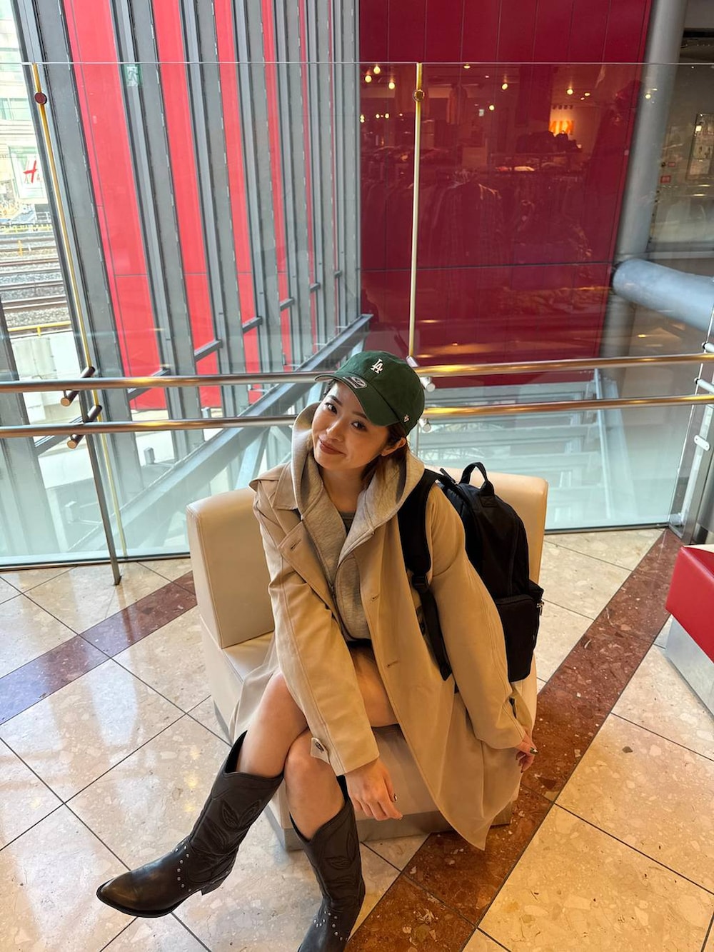 ブラック系のブーツ、ブラック系のバックパック/リュック、グレー系のブルゾンを着用したレディースの春コーディネートの3枚目の写真