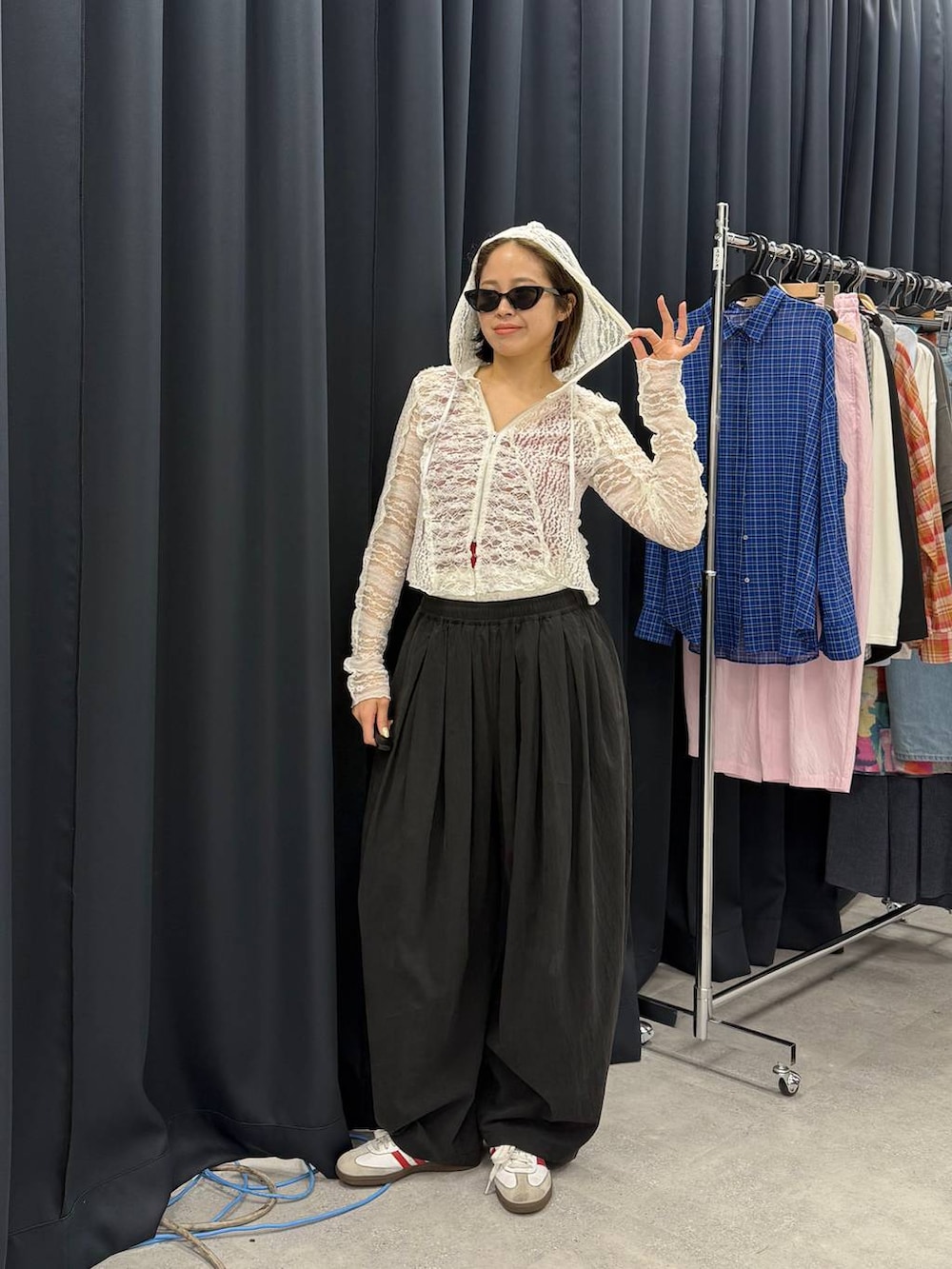 ホワイト系のパーカー、レッド系のタンクトップ、ブラック系のカーゴパンツを着用したレディースの春コーディネートの3枚目の写真