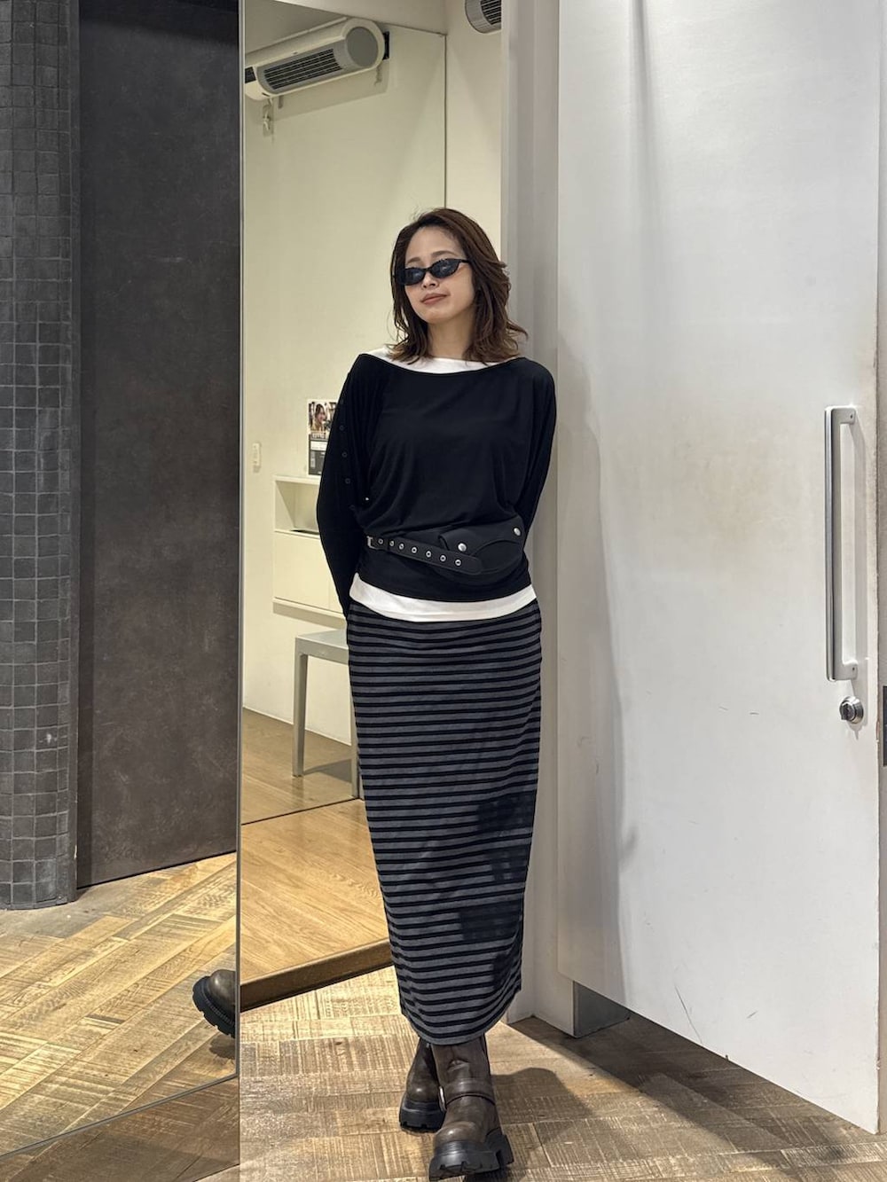 ブラック系のボディバッグ/ウエストポーチ、ブラック系のスカート、ブラック系のTシャツ/カットソーを着用したレディースの夏コーディネートの2枚目の写真