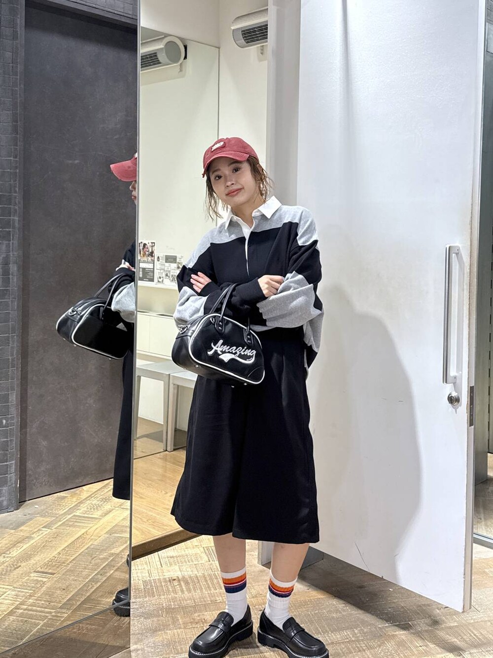 ブラック系のショルダーバッグ、ブラック系のその他パンツ、グレー系のポロシャツを着用したレディースの秋コーディネートの3枚目の写真