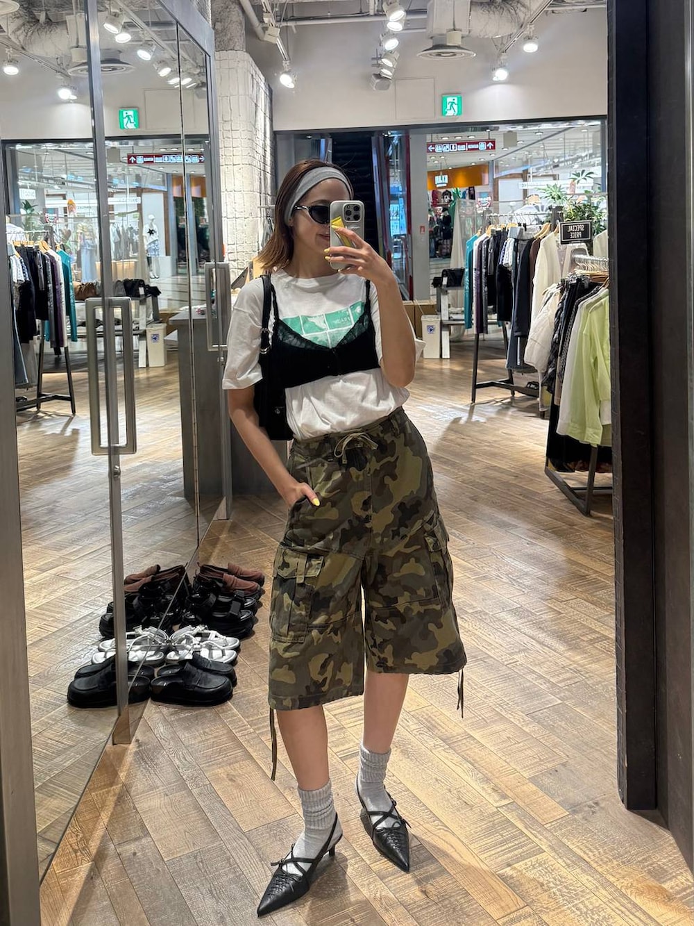 ホワイト系のTシャツ/カットソー、ブラック系のパンプス、ブラック系のショルダーバッグを着用したレディースの夏コーディネートの2枚目の写真