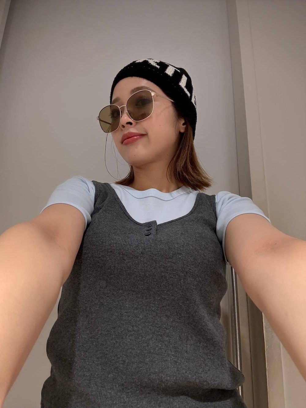 グレー系のタンクトップ、ブルー系のTシャツ/カットソー、グレー系のサングラスを着用したレディースの春コーディネートの2枚目の写真
