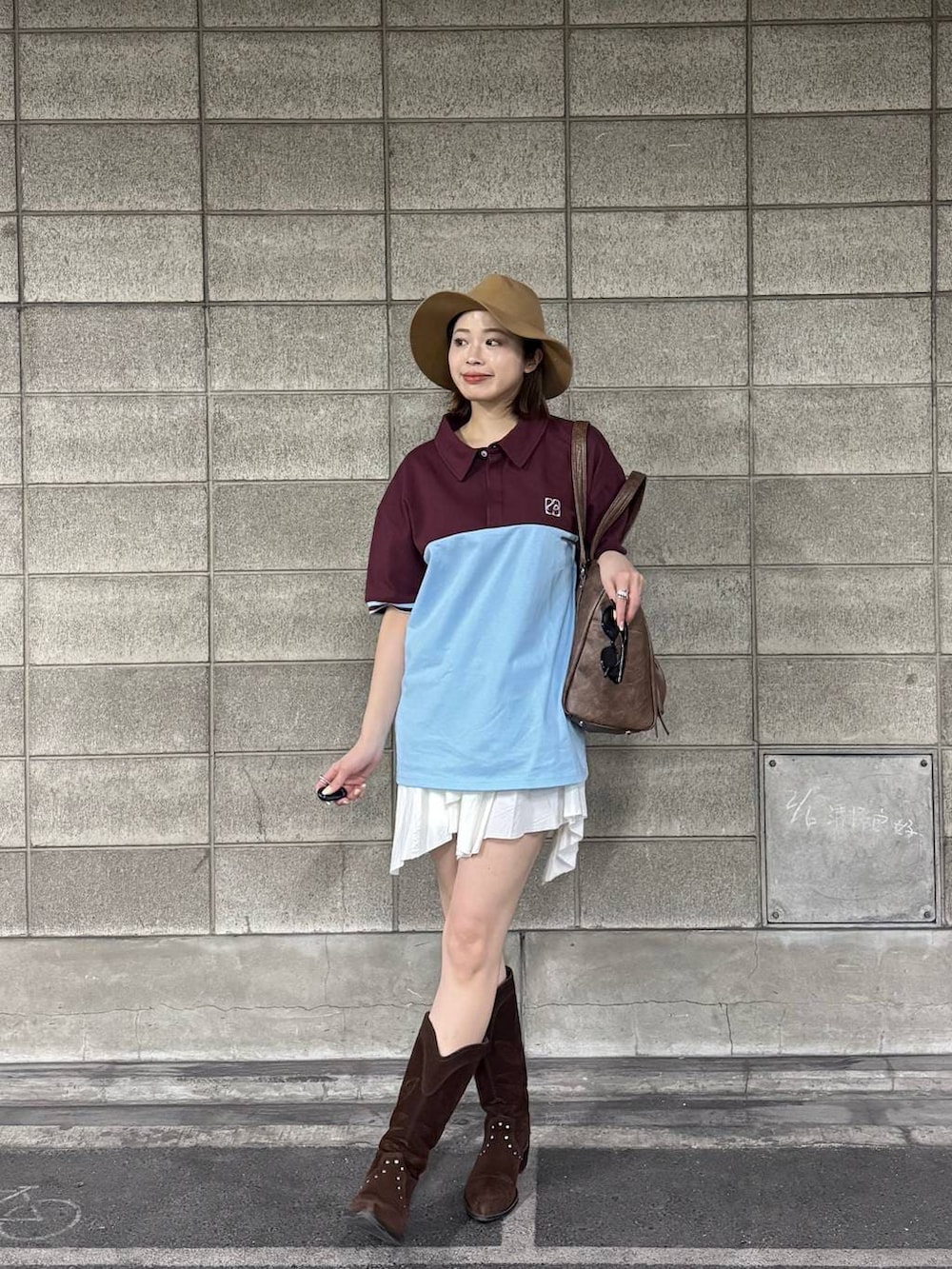 ブラウン系のブーツ、ブラウン系のトートバッグ、ホワイト系のスカートを着用したレディースの春コーディネートの2枚目の写真