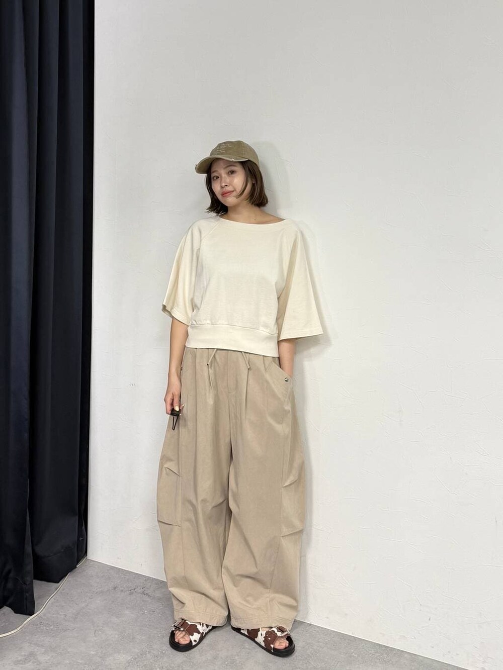 ホワイト系のスウェット、ベージュ系のその他パンツ、ホワイト系のサンダルを着用したレディースの春コーディネートの2枚目の写真