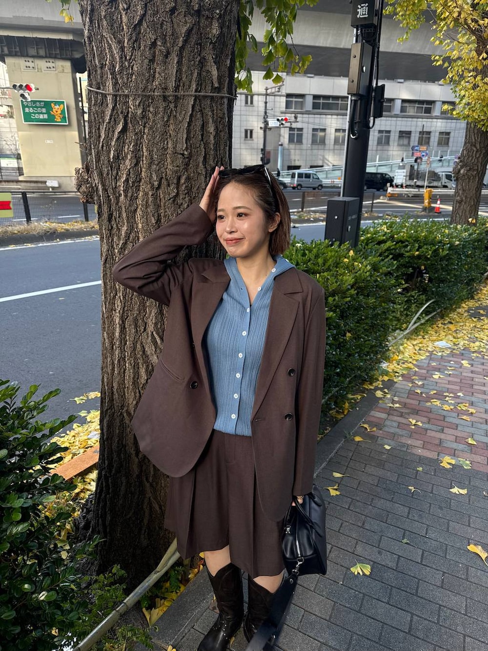 ブラウン系のテーラードジャケット、ブラック系のボストンバッグ、ブラック系のブーツを着用したレディースの冬コーディネートの4枚目の写真