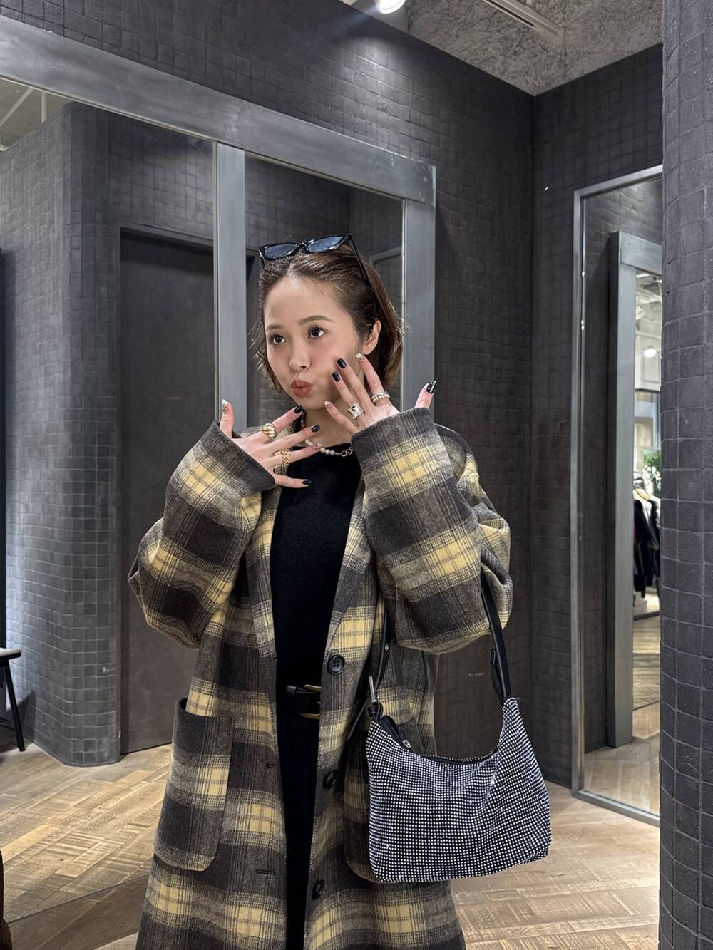 ブラウン系のチェスターコート、ブラック系のハンドバッグ、シルバー系のリングを着用したレディースの冬コーディネートの2枚目の写真