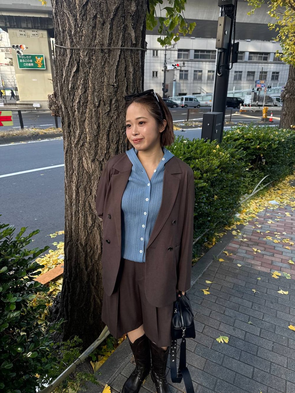 ブラウン系のテーラードジャケット、ブラック系のボストンバッグ、ブラック系のブーツを着用したレディースの冬コーディネートの2枚目の写真