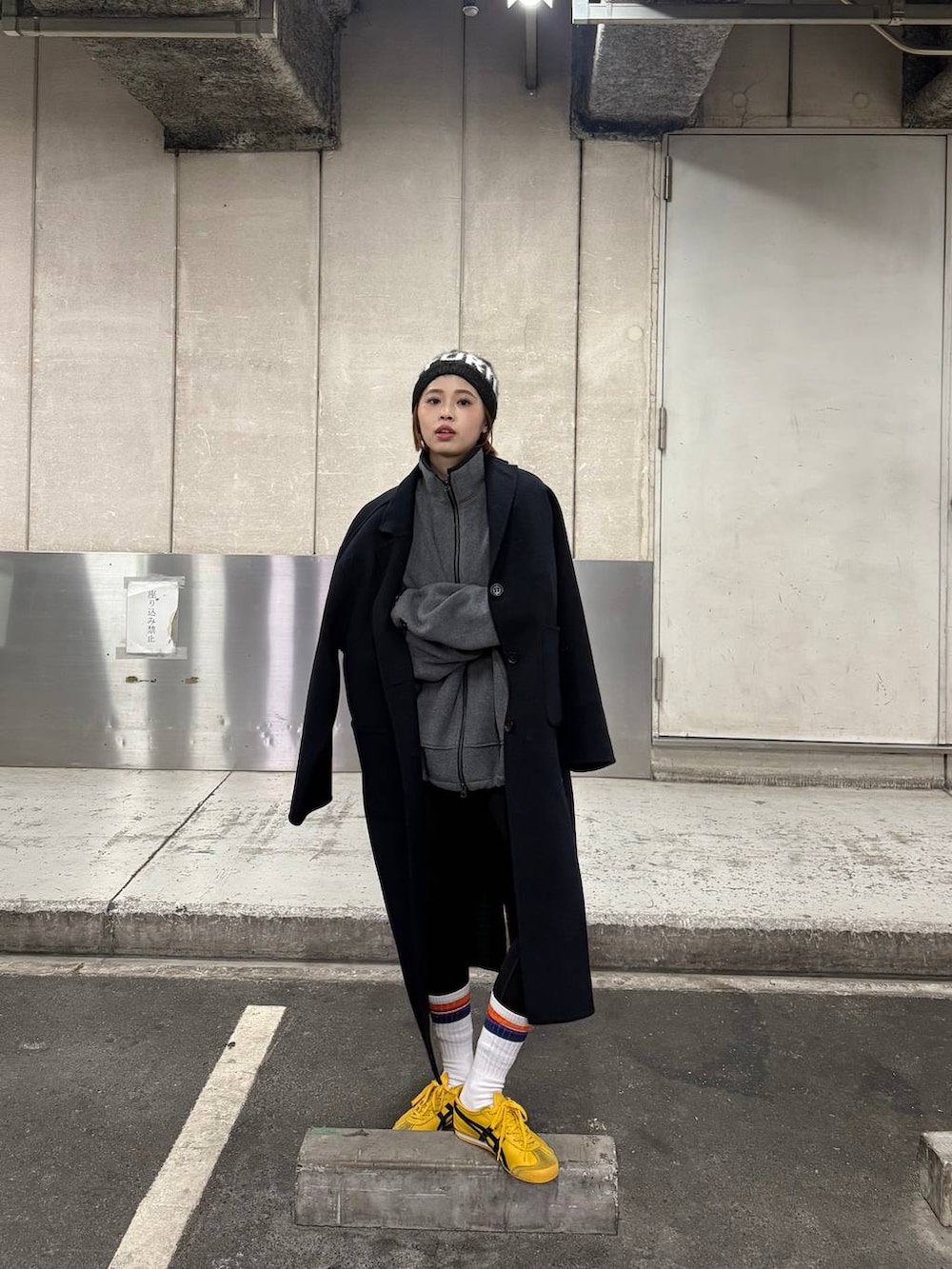 ブルー系のチェスターコート、グレー系のブルゾン、ブラック系のニットキャップ/ビーニーを着用したレディースの秋コーディネートの3枚目の写真