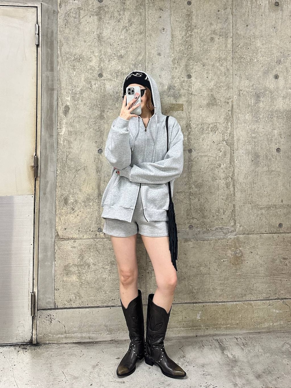 ブラック系のブーツ、グレー系のスウェットパンツ、グレー系のパーカーを着用したレディースの春コーディネートの3枚目の写真
