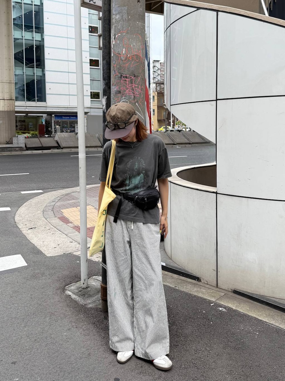 グレー系のTシャツ/カットソー、ホワイト系のデニムパンツ、ブラック系のボディバッグ/ウエストポーチを着用したレディースの夏コーディネートの2枚目の写真