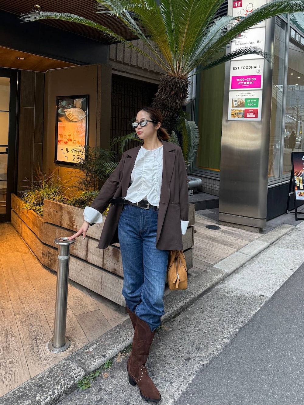 ブラウン系のテーラードジャケット、ブラウン系のボストンバッグ、ブラウン系のブーツを着用したレディースの春コーディネートの3枚目の写真