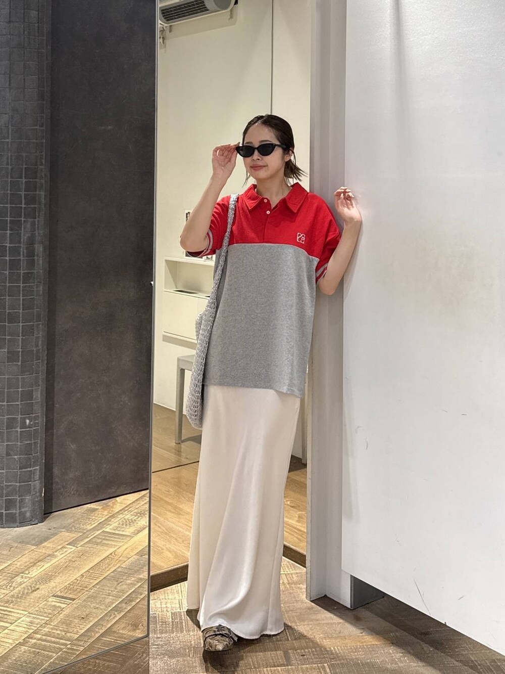 シルバー系のショルダーバッグ、ベージュ系のパンプス、ホワイト系のスカートを着用したレディースの春コーディネートの3枚目の写真