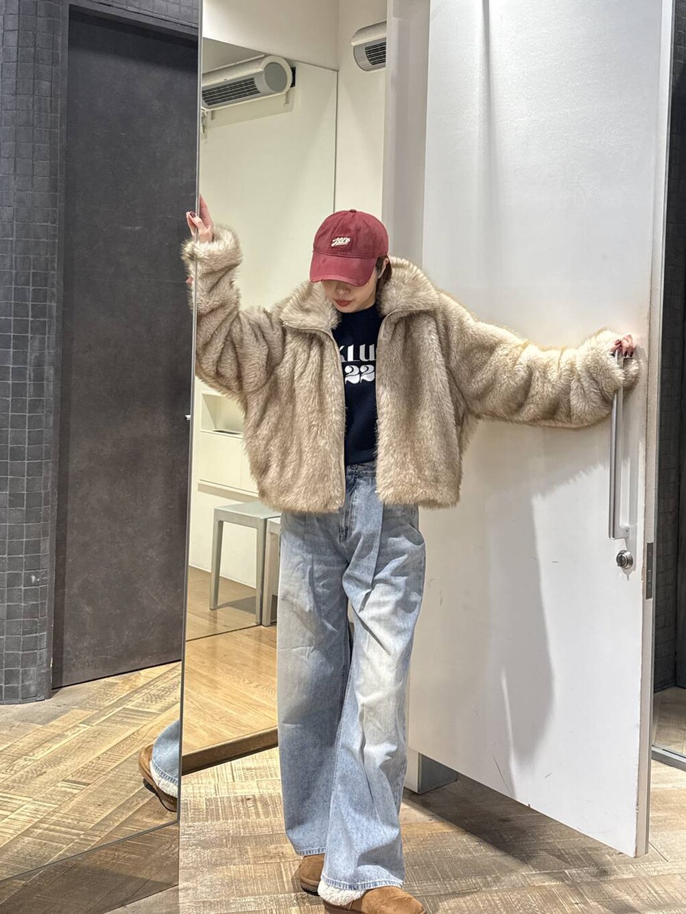 ベージュ系のブルゾン、ブルー系のデニムパンツ、ブルー系のニット/セーターを着用したレディースの冬コーディネートの2枚目の写真