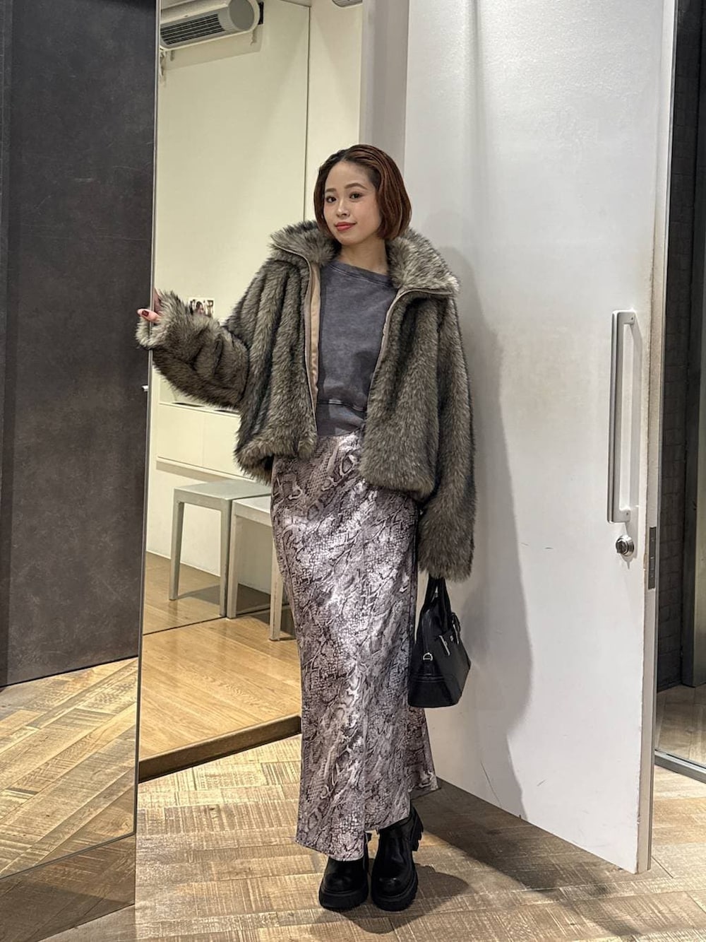 ベージュ系のブルゾン、ブラック系のブーツ、グレー系のスウェットを着用したレディースの冬コーディネートの3枚目の写真