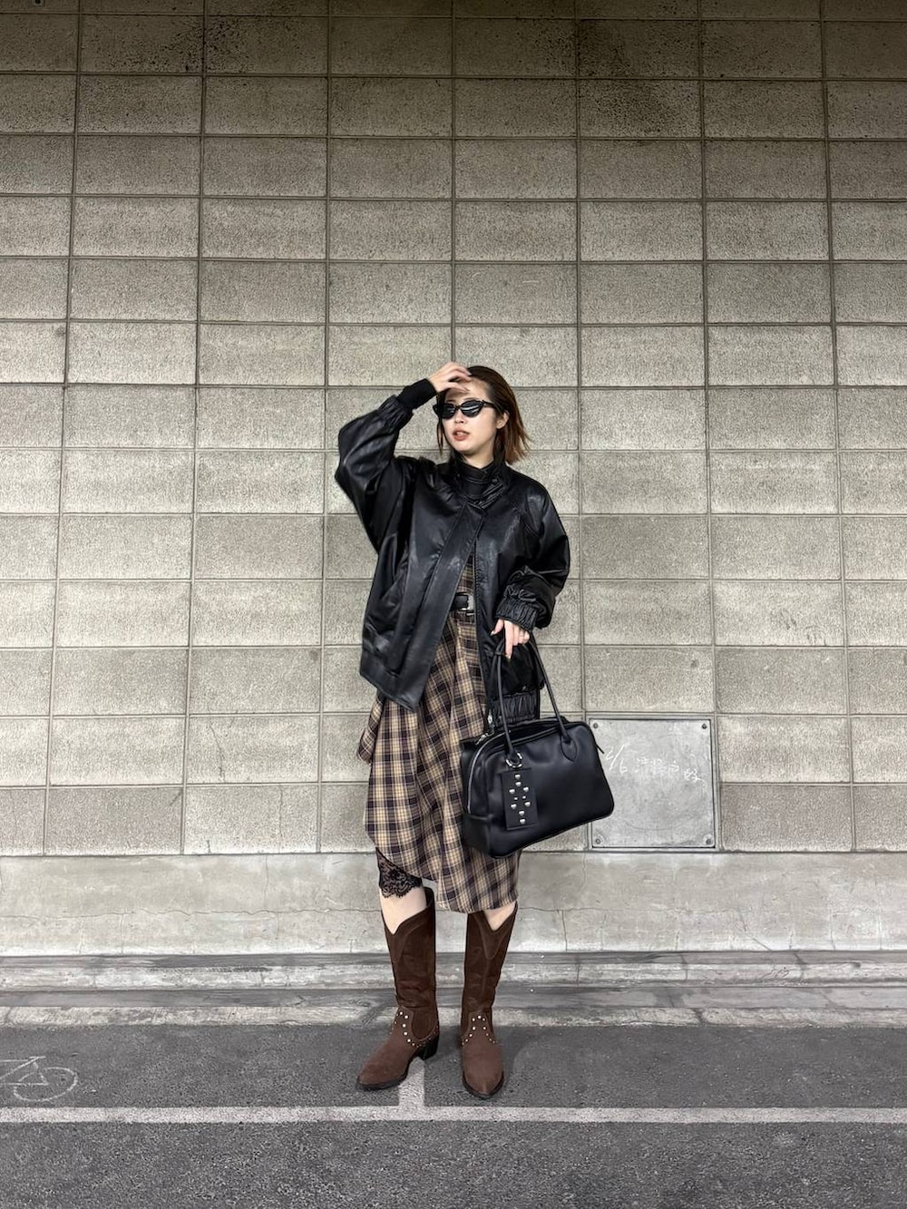 ブラック系のボストンバッグ、ブラウン系のブーツ、ブラック系のブルゾンを着用したレディースの冬コーディネートの5枚目の写真