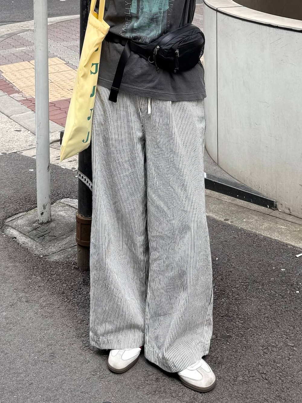 グレー系のTシャツ/カットソー、ホワイト系のデニムパンツ、ブラック系のボディバッグ/ウエストポーチを着用したレディースの夏コーディネートの3枚目の写真