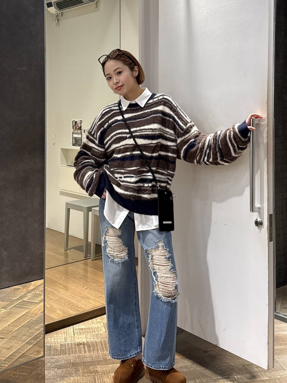 ブラウン系のその他シューズ、ホワイト系のシャツ/ブラウス、ブルー系のデニムパンツを着用したレディースの秋コーディネートの2枚目の写真