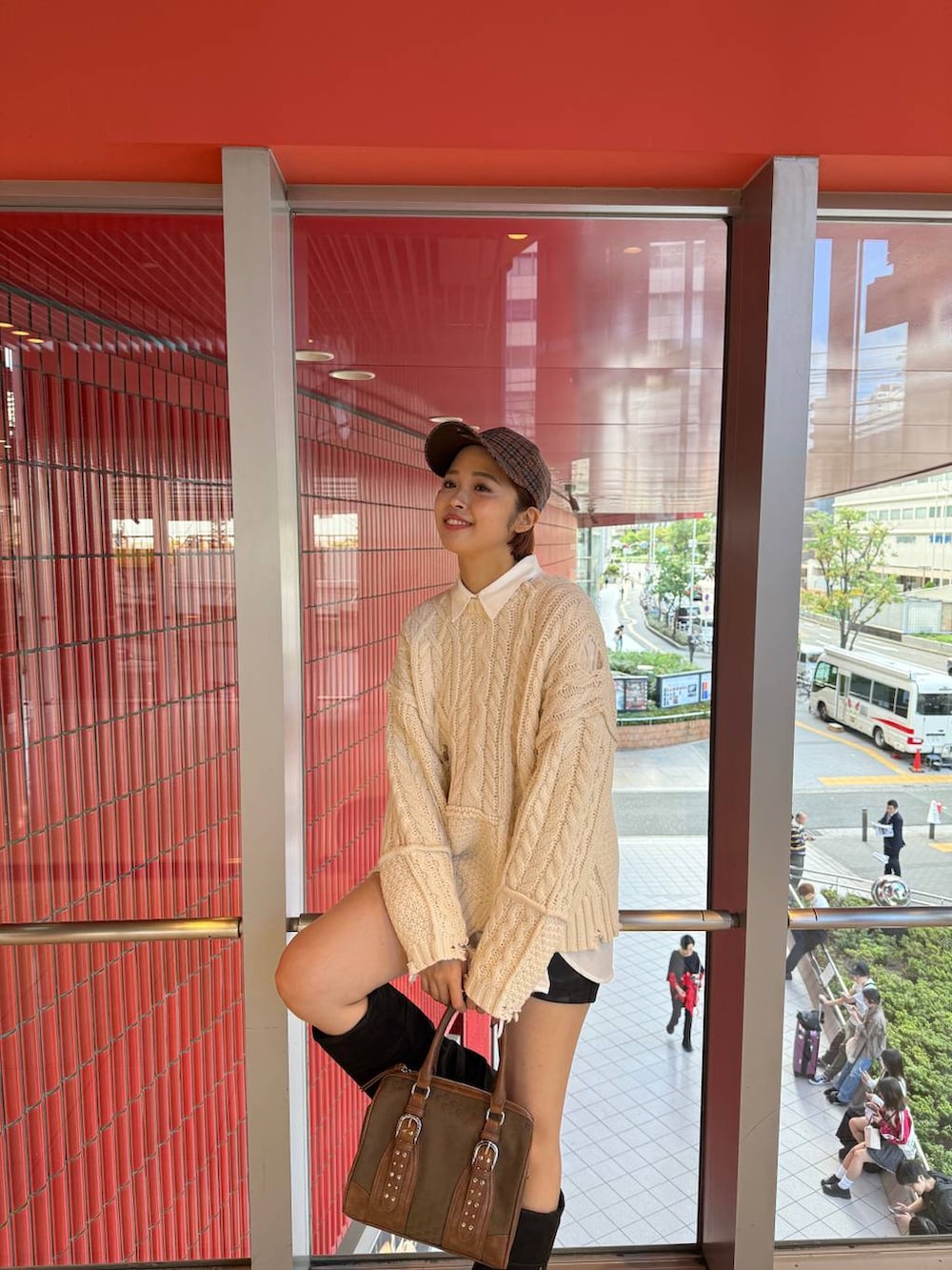 グリーン系のボストンバッグ、ブラック系のブーツ、ホワイト系のシャツ/ブラウスを着用したレディースの秋コーディネートの3枚目の写真