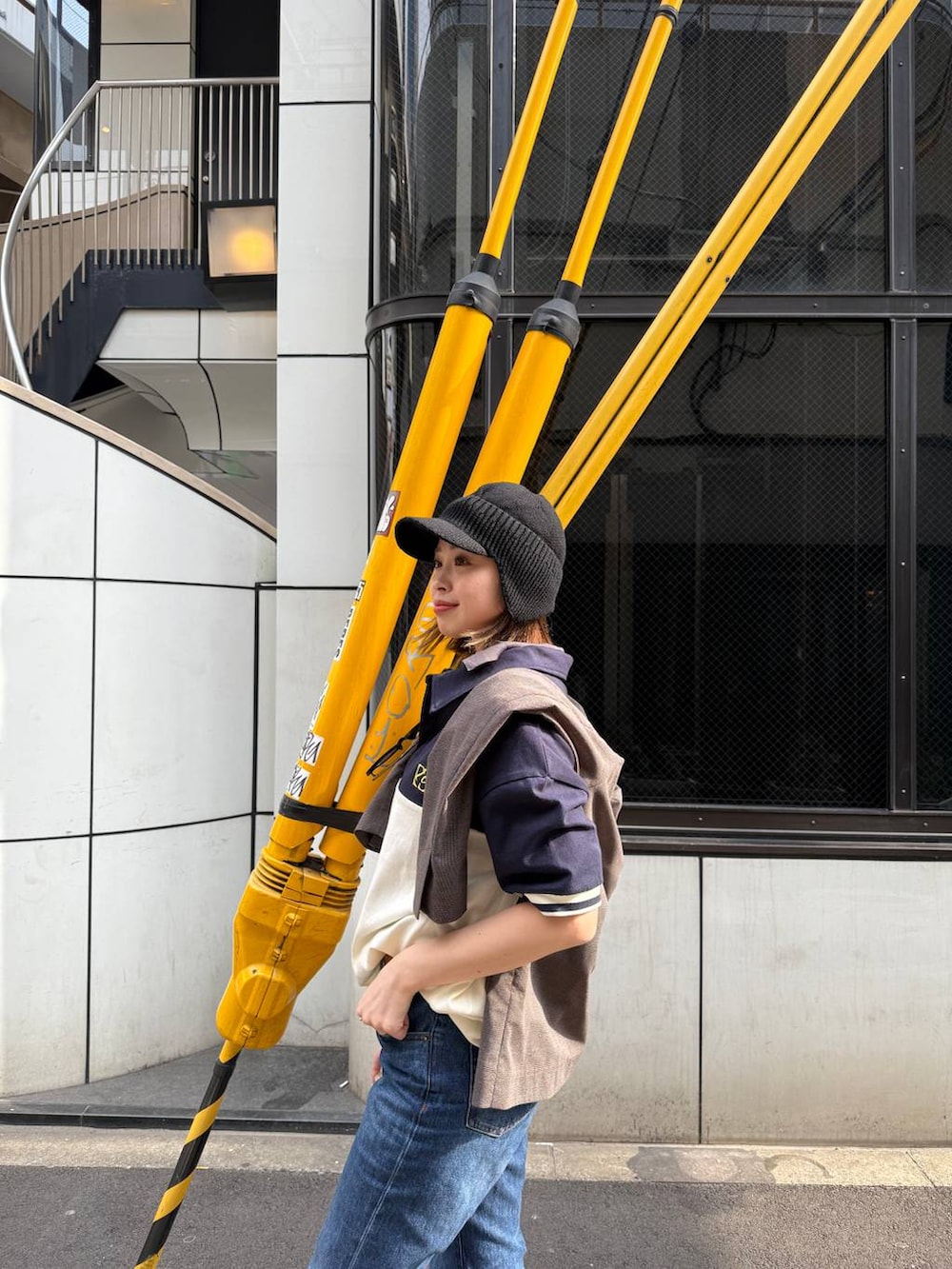 ブラウン系のブーツ、ブルー系のデニムパンツ、ベージュ系のベルトを着用したレディースの春コーディネートの2枚目の写真