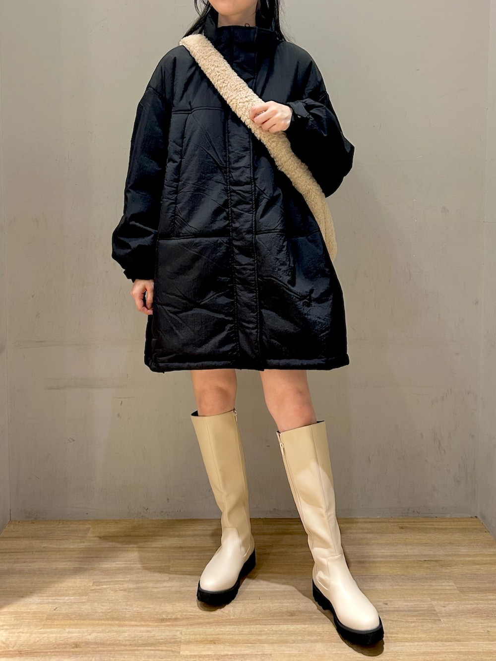 ブラック系のその他アウター、ベージュ系のショルダーバッグ、ホワイト系のブーツを着用したレディースの冬コーディネートの2枚目の写真