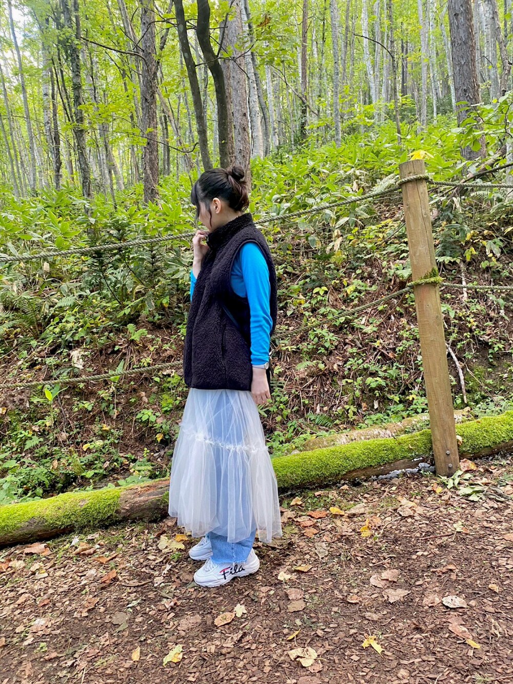 ホワイト系のスカート、ブルー系のデニムパンツを着用したレディースの秋コーディネートの2枚目の写真