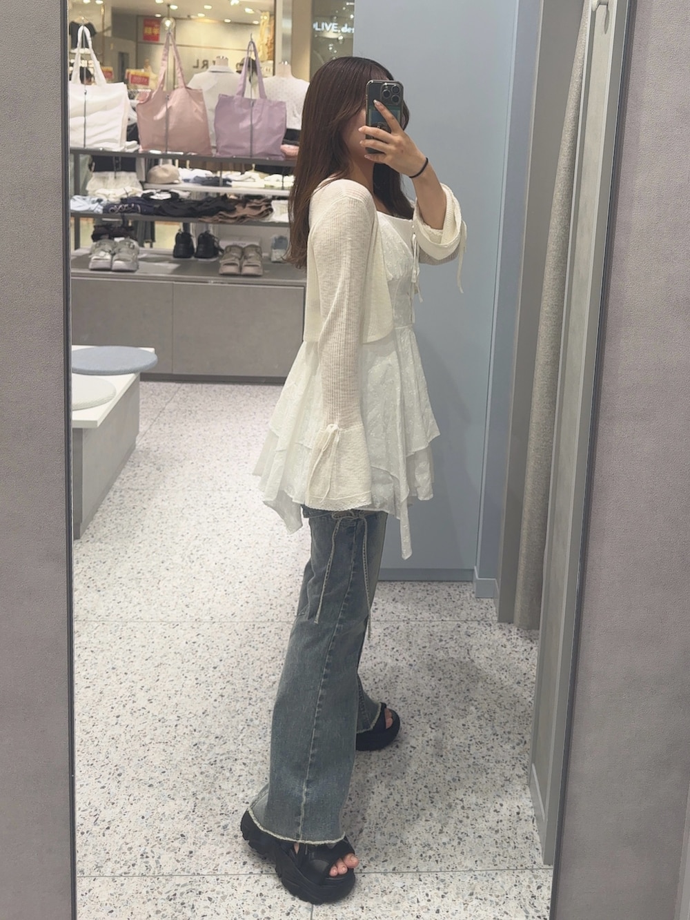 ホワイト系のカーディガン/ボレロ、ホワイト系のワンピース、ブルー系のデニムパンツを着用したレディースの夏コーディネートの2枚目の写真