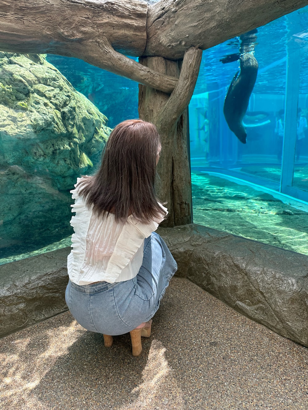 ブラック系のサンダル、ホワイト系のトップス、ブルー系のスカートを着用したレディースの夏コーディネートの2枚目の写真