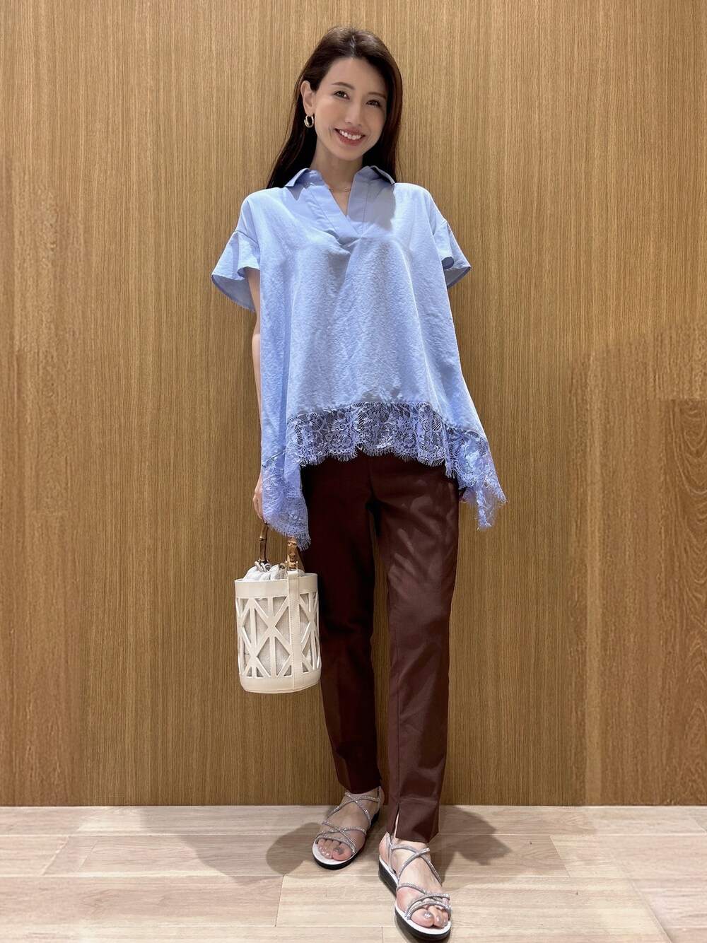ブルー系のシャツ/ブラウス、ブラウン系のその他パンツ、ホワイト系のハンドバッグを着用したレディースの春コーディネートの4枚目の写真