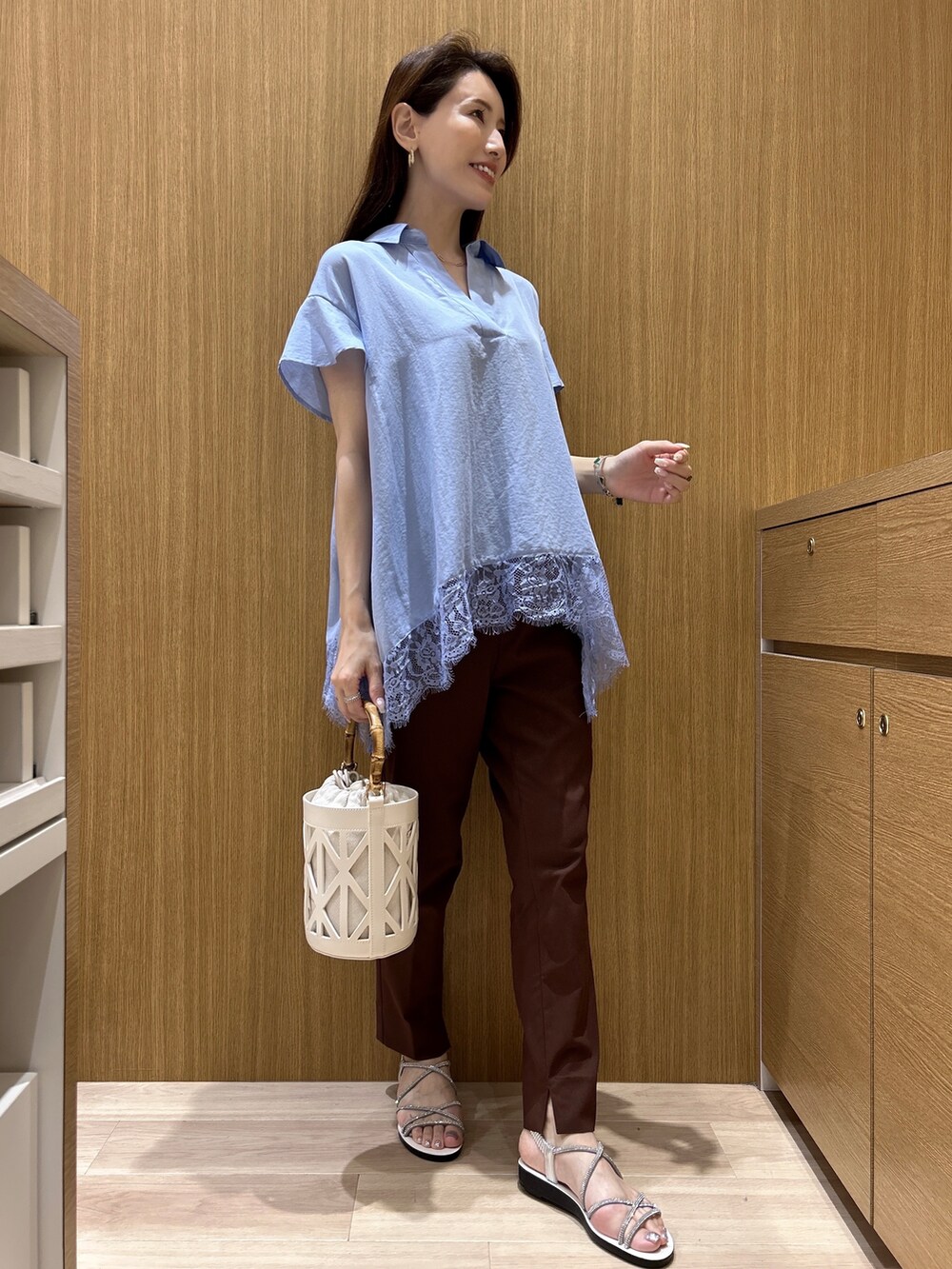 ブルー系のシャツ/ブラウス、ブラウン系のその他パンツ、ホワイト系のハンドバッグを着用したレディースの春コーディネートの5枚目の写真