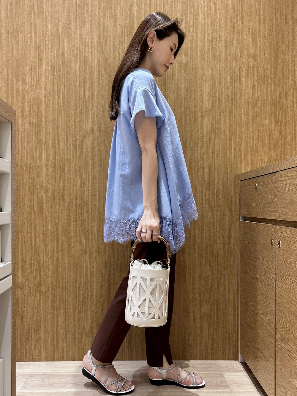 ブルー系のシャツ/ブラウス、ブラウン系のその他パンツ、ホワイト系のハンドバッグを着用したレディースの春コーディネートの9枚目の写真