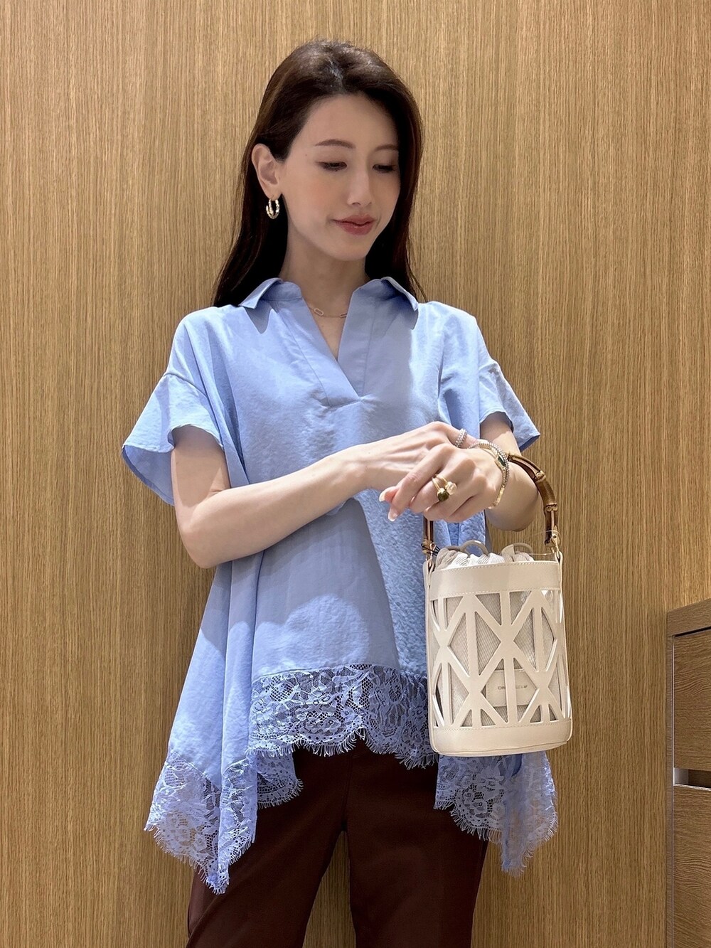 ブルー系のシャツ/ブラウス、ブラウン系のその他パンツ、ホワイト系のハンドバッグを着用したレディースの春コーディネートの6枚目の写真
