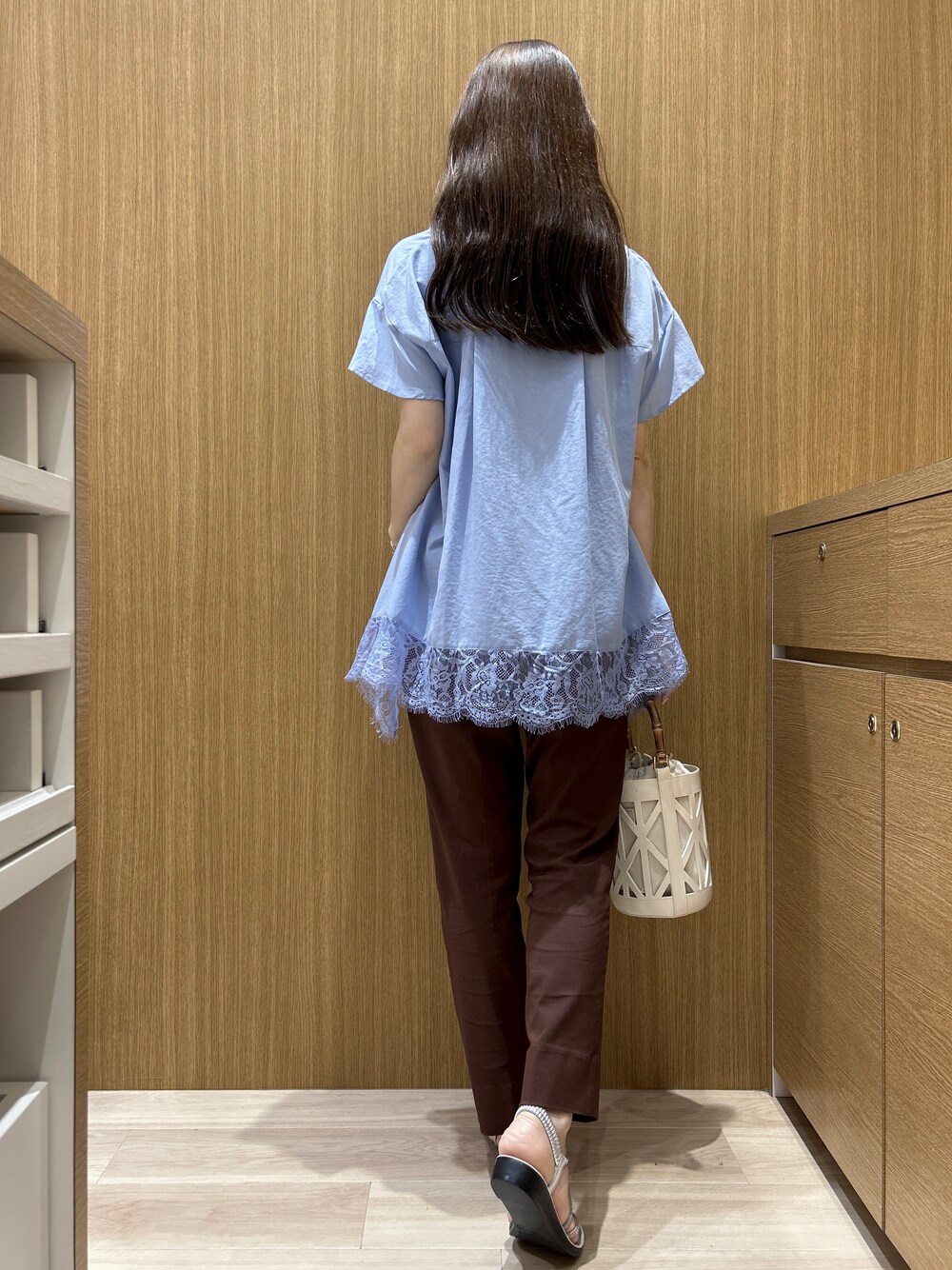 ブルー系のシャツ/ブラウス、ブラウン系のその他パンツ、ホワイト系のハンドバッグを着用したレディースの春コーディネートの7枚目の写真